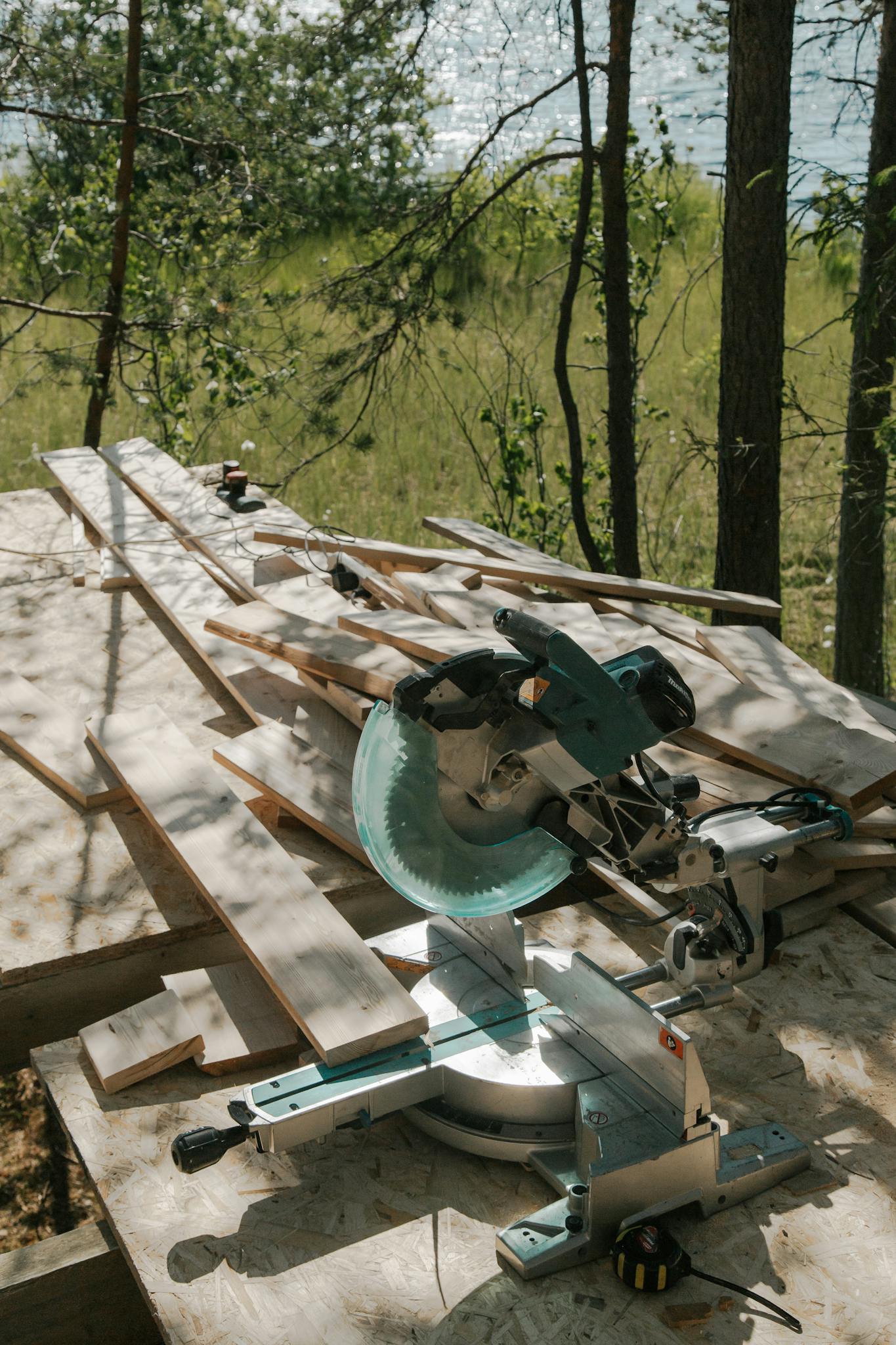 Circular saw on wooden planks at an outdoor construction site in a forest.